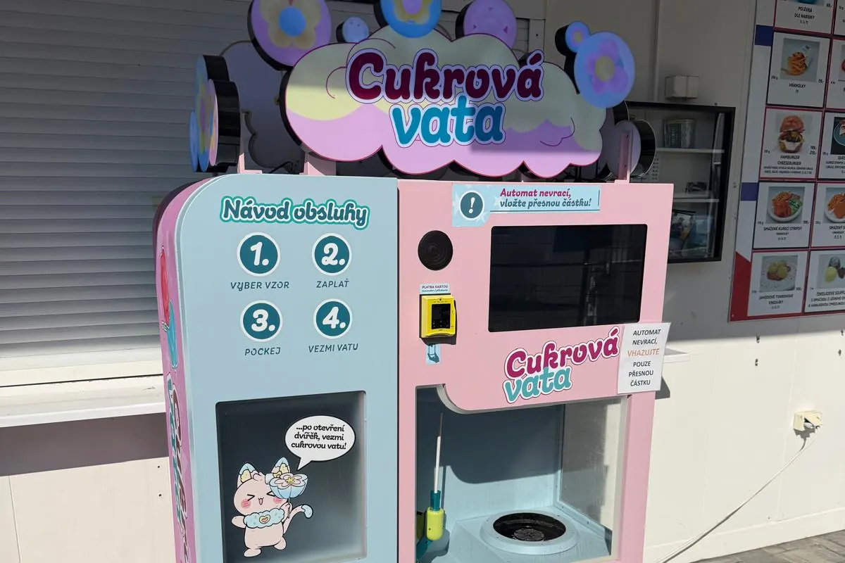 Růžový automat na cukrovou vatu s návodem obsluhy u stánku s občerstvením