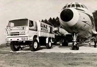 Historická fotografie — kamion LIAZ na trávníku u letounu Il-18